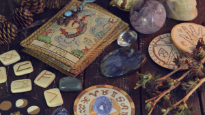Zestaw narzędzi do praktyk Wicca: runy, kryształy, karty tarota i inne symbole ezoteryczne na drewnianym stole.