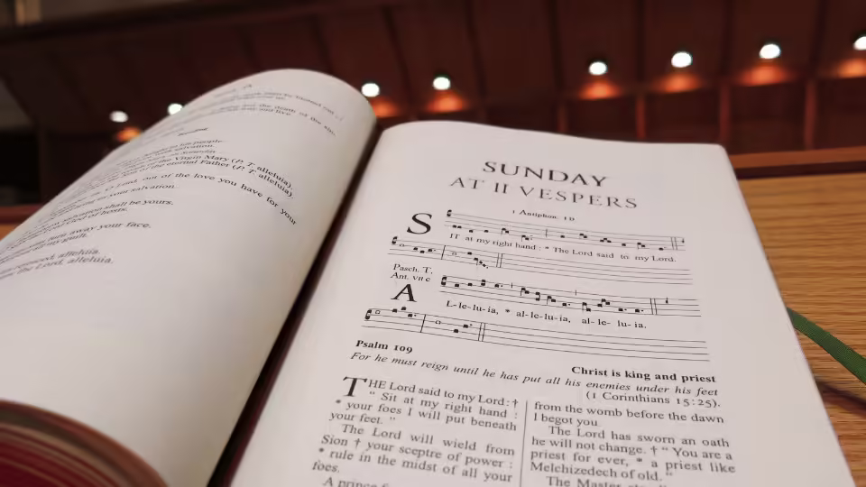 Otwarta księga z nutami i tekstem modlitwy gregoriańskiej, przedstawiająca zapis śpiewów liturgicznych, które mają związek z częstotliwościami Solfeggio, używanymi od średniowiecza w muzyce sakralnej.