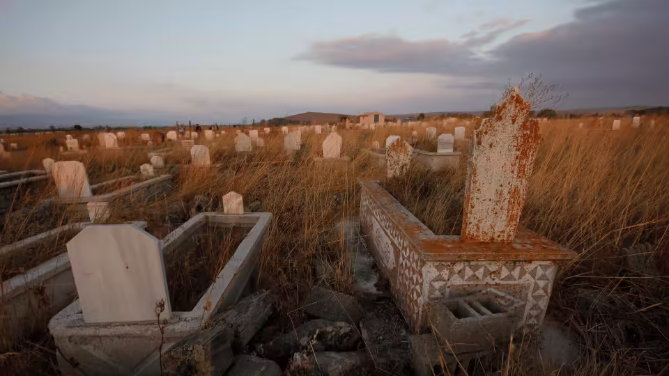 Cmentarz w Tana Toraja, z nagrobkami otoczonymi wysoką trawą, przygotowany do rytuału manene, podczas którego rodziny odwiedzają swoich przodków.
