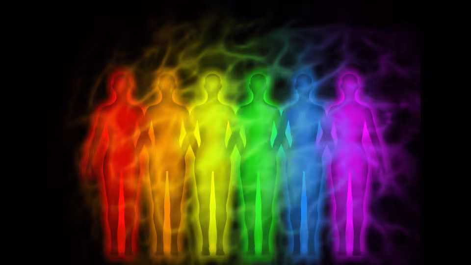 Graficzne przedstawienie sylwetek ludzkich otoczonych różnokolorowymi aurami, symbolizujące koncepcję pola energetycznego człowieka i znaczenie kolorów aury.