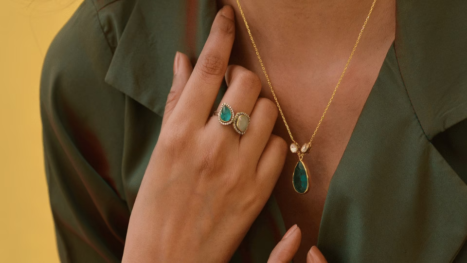 Zielony strój uzupełniony biżuterią z kamieniami szlachetnymi – akwamarynem i opalem – symbolizującą harmonię i intuicję, idealną na Sylwestra zgodnie z astrologiczną energią planet.