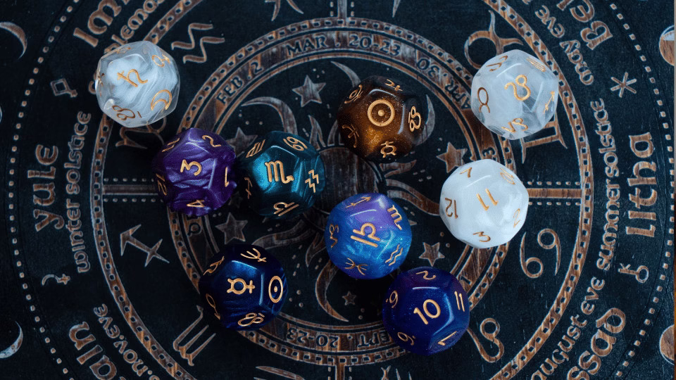 Kolorowe kostki z symbolami zodiaku na tle koła astrologicznego, symbolizujące tajemnice ascendenta i astrologii.