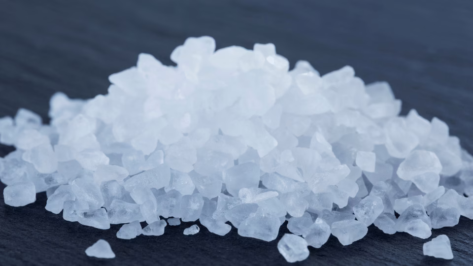 Krystaliczna sól na ciemnym tle – naturalne minerały przypominające bryły lodu, symbol czystości i prostoty.